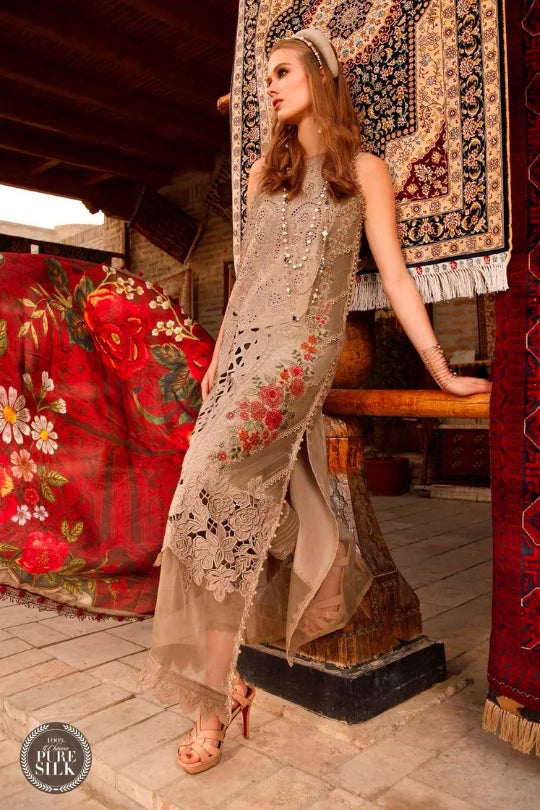Elegant woman in embroidered beige dress, showcasing floral designs against a vibrant traditional backdrop.