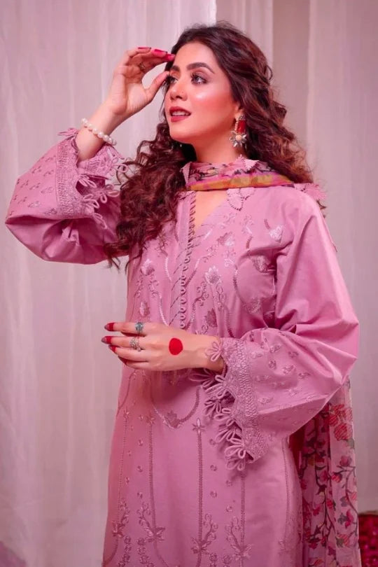 Elegant woman in a pink embroidered dress with a stylish dupatta, showcasing modern Pakistani fashion.