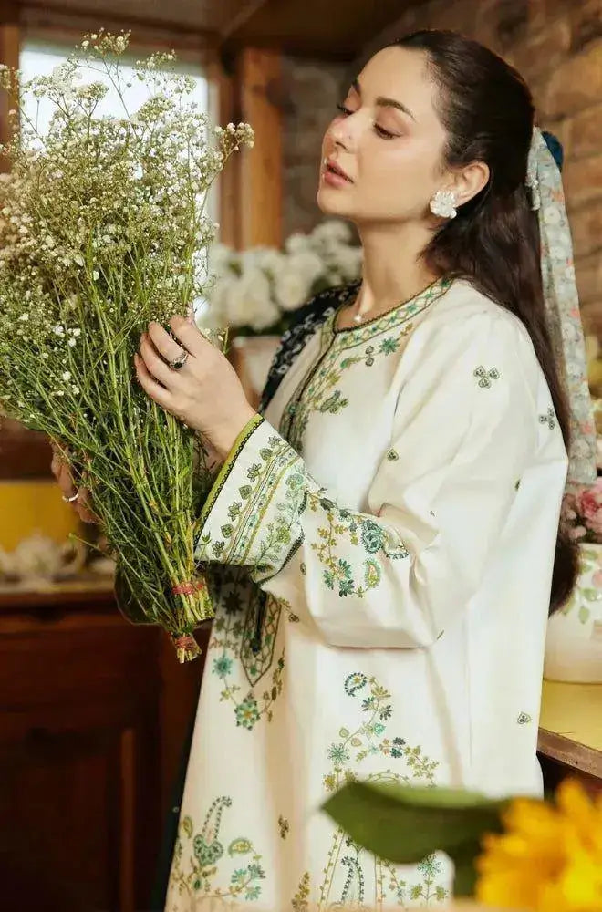 Model showcasing an elegant embroidered outfit from the Winter Wedding Collection while holding fresh flowers.