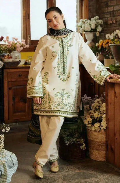 Model wearing a traditional white and green outfit from the Winter Wedding Collection in a cozy indoor setting.