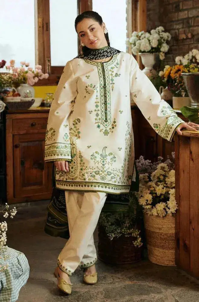 Model wearing a traditional white and green outfit from the Winter Wedding Collection in a cozy indoor setting.