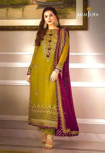 Model showcasing ASIM JOFA winter wedding collection in a vibrant green and maroon traditional outfit with intricate embroidery.